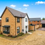 Modern brick house with driveway in residential area.