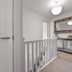Hallway with decorative mirror and white railing