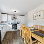 Modern kitchen with wooden dining table and chairs.