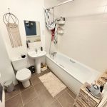 Modern bathroom with bathtub, sink, and toilet.