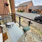 Small balcony with hanging chair and table.