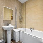 Modern bathroom with bathtub and basin.