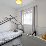 Children's bedroom with bed and crib.