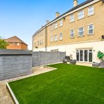 Modern backyard with lawn and patio seating.