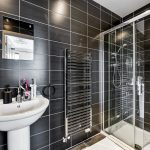 Modern bathroom with sink, mirror, and shower.