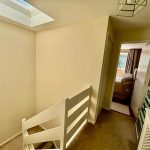 Upstairs hallway with skylight and bedroom view.