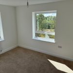 Bright empty room with two large windows.