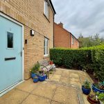 House entrance with blue door and garden bench.