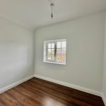 Empty room with window and wooden floor.
