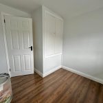 Empty room with wooden floor and white walls.