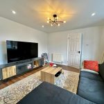 Modern living room with TV and sofa.