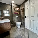 Modern bathroom with sink, toilet, and towel rail