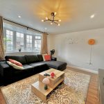 Modern living room with black sofa and decorations.