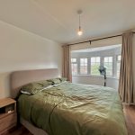 Bright bedroom with double bed and bay window.