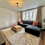 Modern living room with large sofa and window.