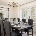 Elegant dining room with chandelier and window view.