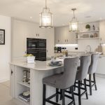 Modern kitchen with island and elegant lighting.