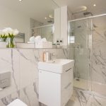 Modern marble bathroom with shower and flowers