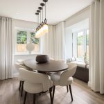 Modern dining room with wooden table and chairs.