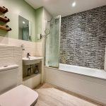 Modern bathroom with shower and mint green walls.