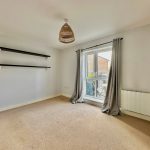 Empty room with carpet and shelves.