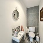 Modern bathroom with basin, mirror, and toilet.