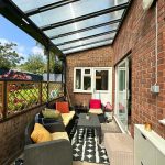 Cosy garden patio with outdoor seating and table.