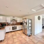 Spacious modern kitchen with white cabinets and appliances.
