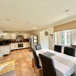 Modern kitchen with dining area and natural light.