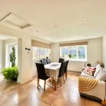 Bright dining room with table, chairs, and sofa.