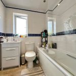 Modern bathroom with white and blue tiles.