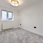 Empty room with grey carpet and white walls.