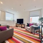 Modern living room with colourful striped rug.
