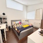 Cozy bedroom with bed and home office setup.