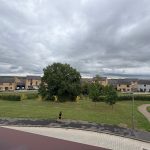 Cloudy sky over residential area with lone runner