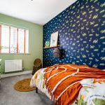 Dinosaur-themed children's bedroom with green walls.
