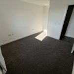 Empty room with grey carpet and white walls.