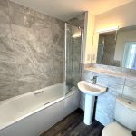 Modern bathroom with bathtub, sink, and toilet