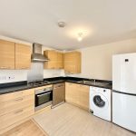 Modern kitchen with wooden cabinets and appliances.
