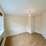 Empty room with wooden floor and white walls.