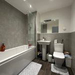 Modern bathroom with bathtub, sink, and toilet.