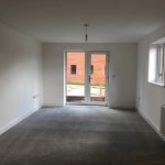 Empty room with large window and carpet.