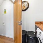 Open bathroom door revealing laundry room