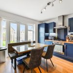 Modern kitchen with dining table and blue cabinets.