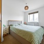 Bright bedroom with wooden furniture and window view.