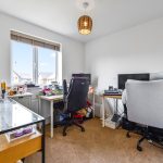 Modern home office with desks and computers.