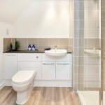 Modern bathroom with shower, sink, and toilet.