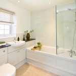 Modern bathroom with bath, sink, and window blinds.