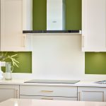 Modern kitchen with green walls and white cabinets