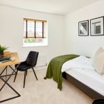 Minimalist bedroom with desk, chair, and bed.